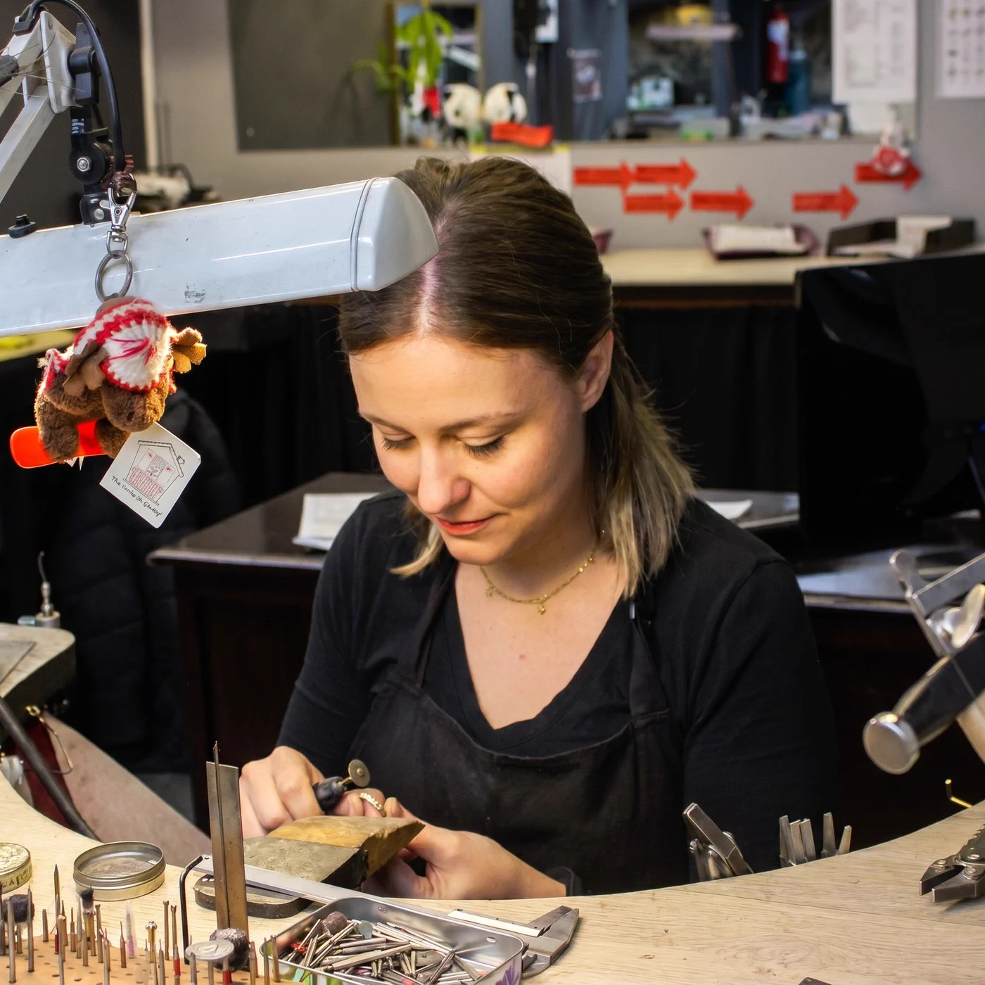 A Prins and Prins goldsmith at her bench, working a piece among her tools